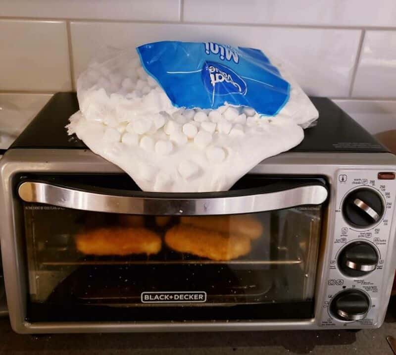 Toaster oven with marshmallows on top and chicken nuggets inside.