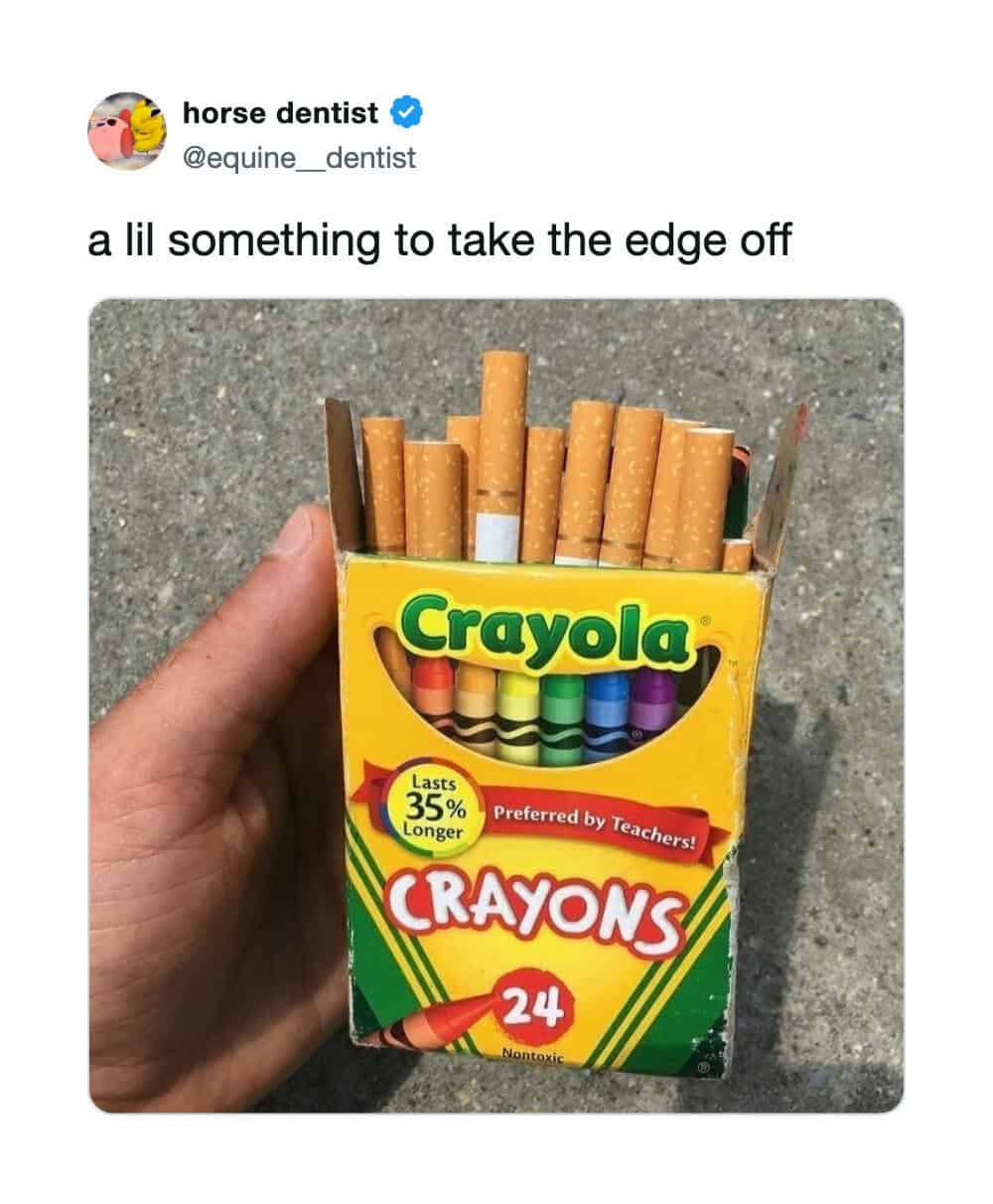 Hand holding a box of Crayola crayons with cigarettes inside, captioned 'a lil something to take the.