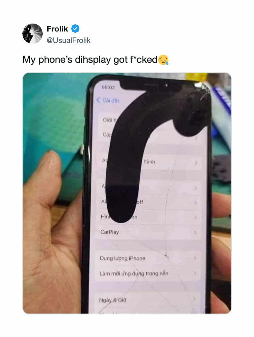 Phone display with a large black object covering the screen, tweet text above.