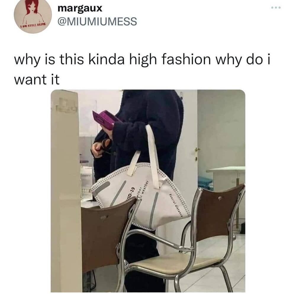 Person holding a pink phone with a white tote bag and chairs in the background.