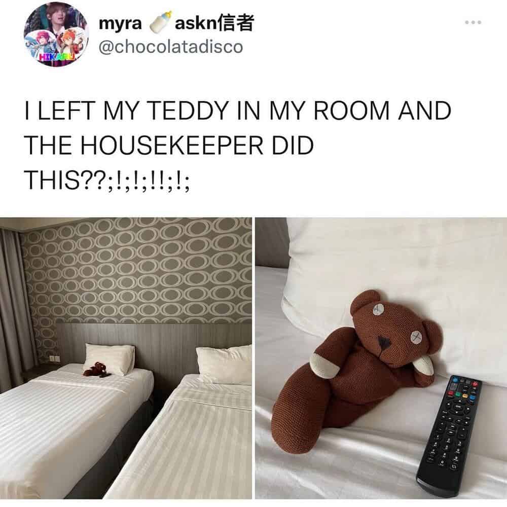Photo of two beds, teddy bear, and remote control in a hotel room.