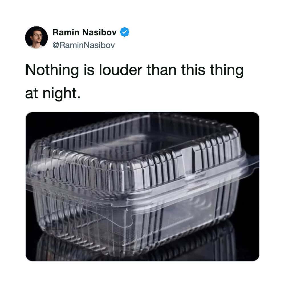 Empty clear plastic food container with black background.