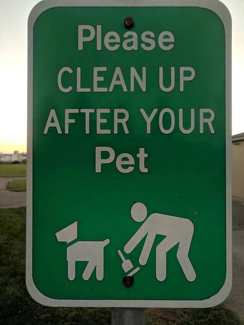 Please CLEAN UP AFTER YOUR Pet sign with a person and dog icon.