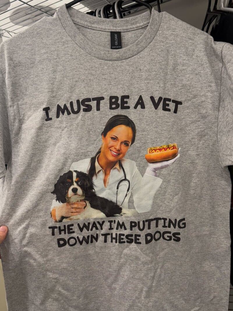 Funny t-shirt with a woman, a dog, and hot dogs, saying 'I must be a vet the way I'm putting down这些狗.