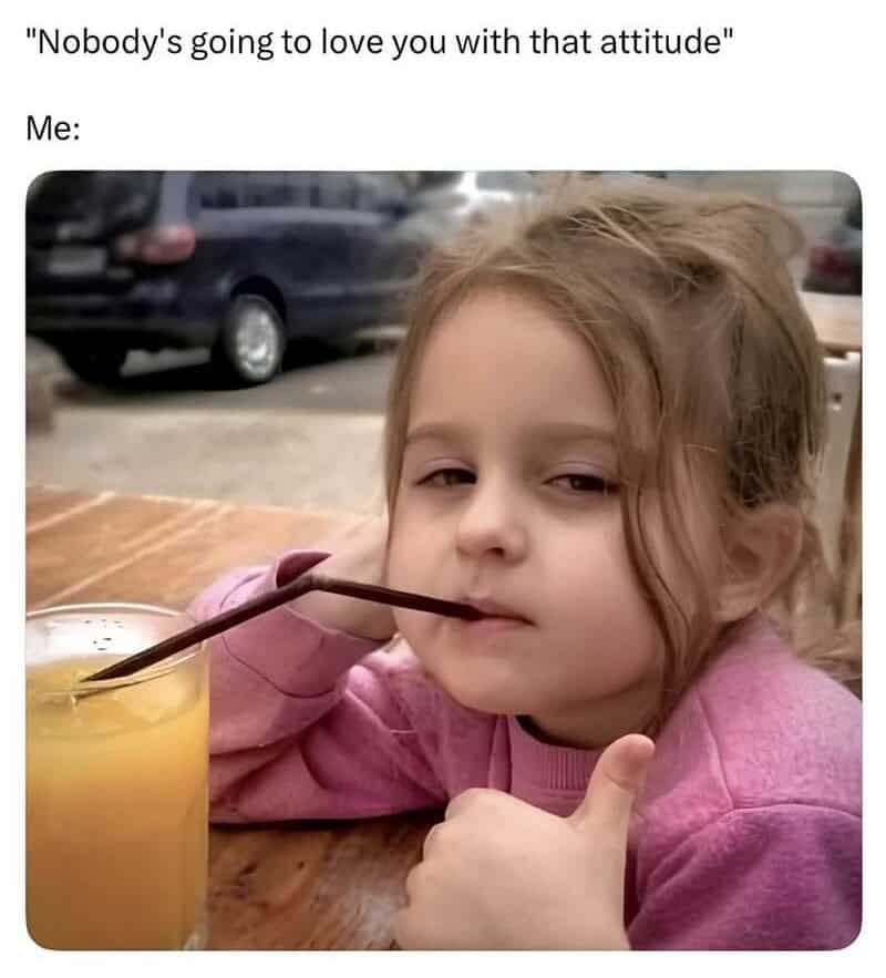 Child with a sassy expression, drinking a beverage with a straw in a glass.