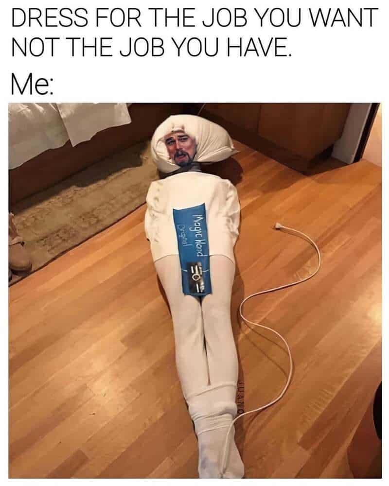 Person in a sock costume with a face mask, lying on the floor, with a blue card on the chest.
