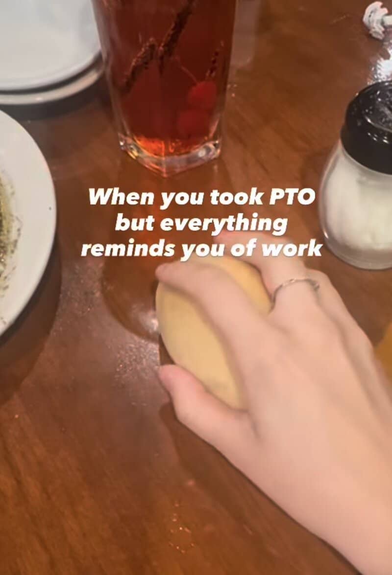 Hand holding a cookie with a drink and sugar on a wooden table, caption about PTO and work.