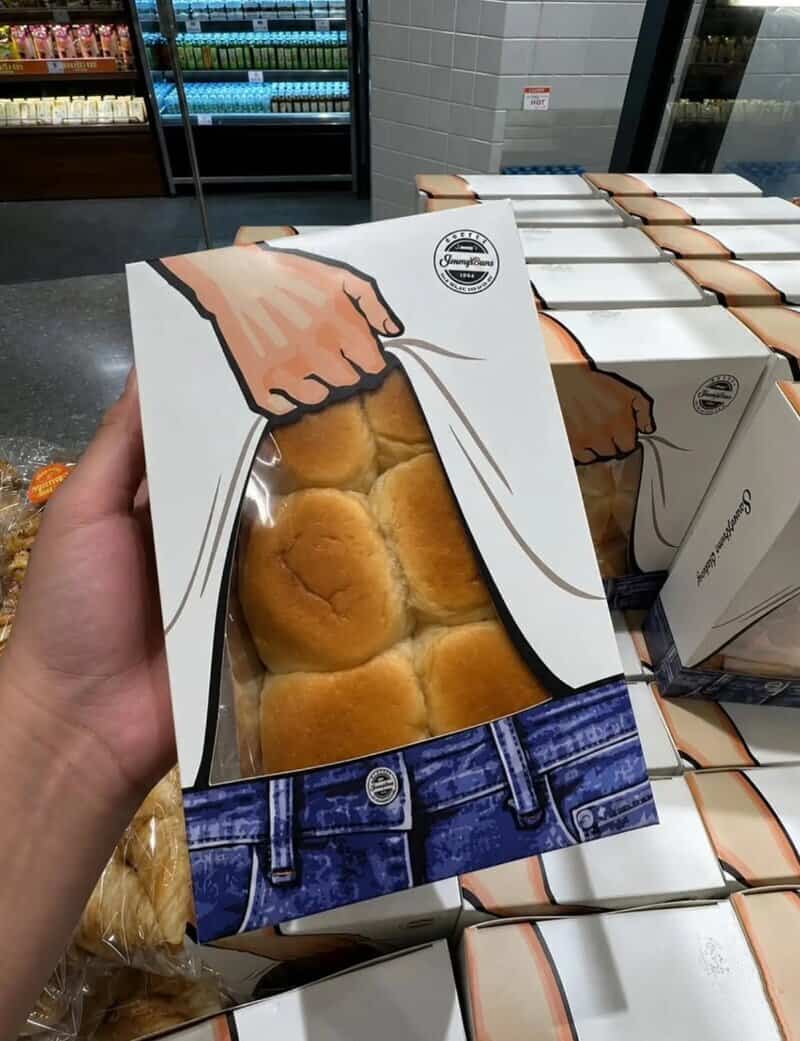 Box of bread rolls with a cartoon illustration of a hand pulling back a paper cover.
