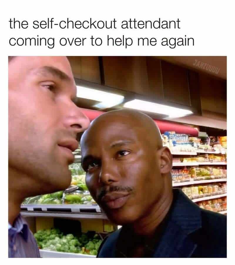 Self-checkout attendant helping a customer in a grocery store.