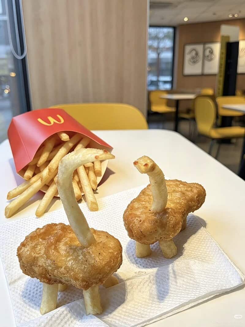 French fries with chicken nuggets shaped like animals with curly fries as necks.