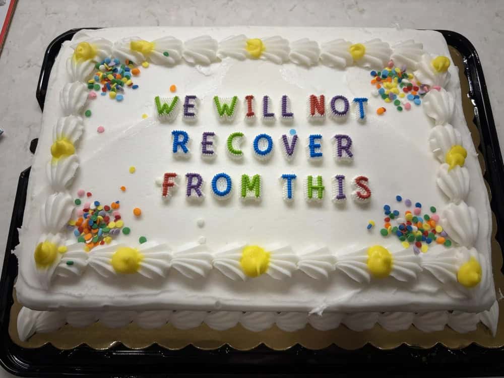 Cake with colorful letters saying 'We will not recover from this' and decorated with sprinkles.