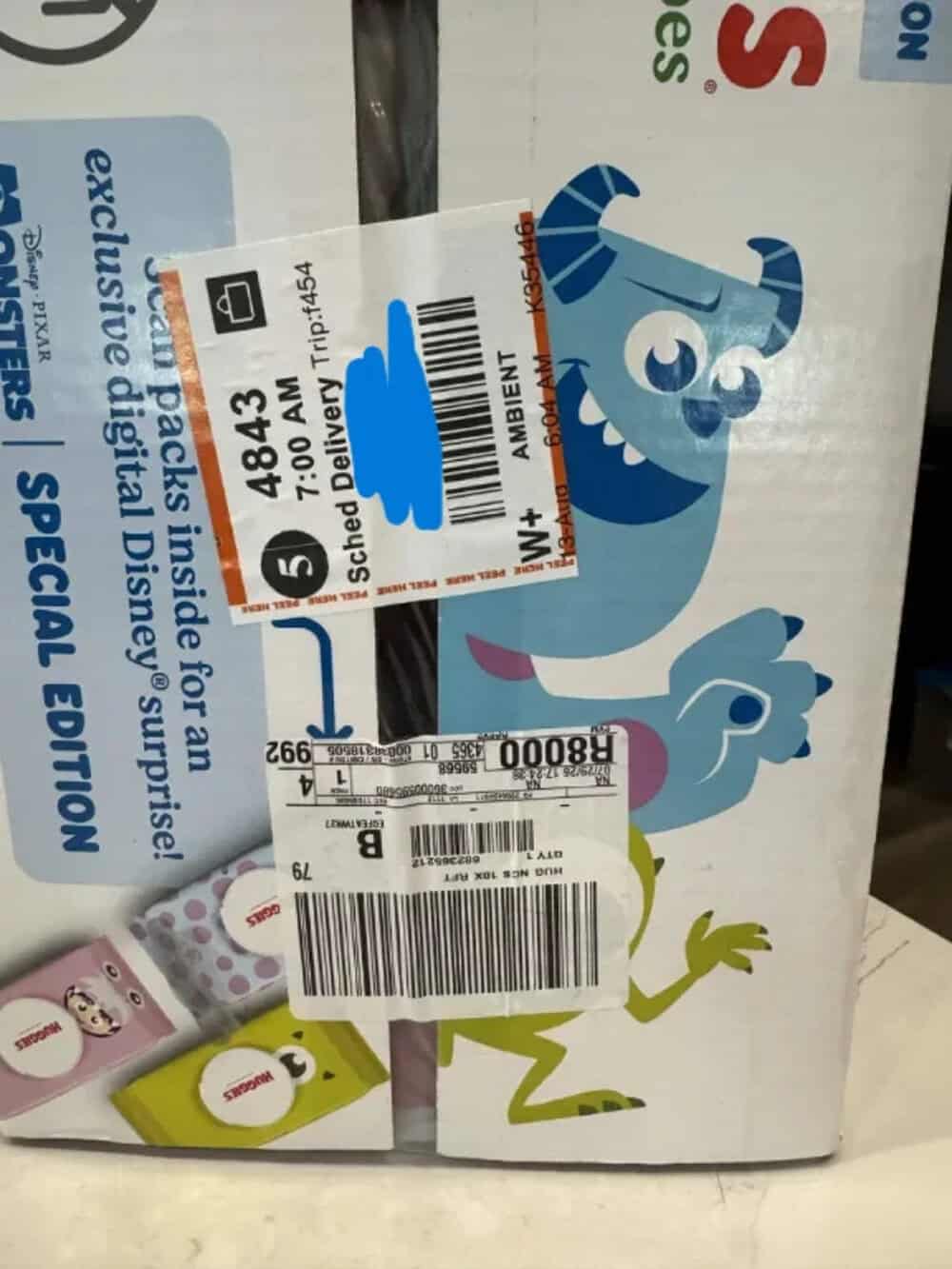 Carton with cartoon characters and delivery labels, including a blue monster and a green frog.