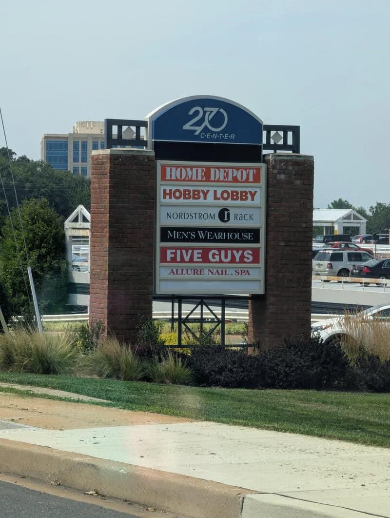 Shopping center sign with various store names including Home Depot and Five Guys.