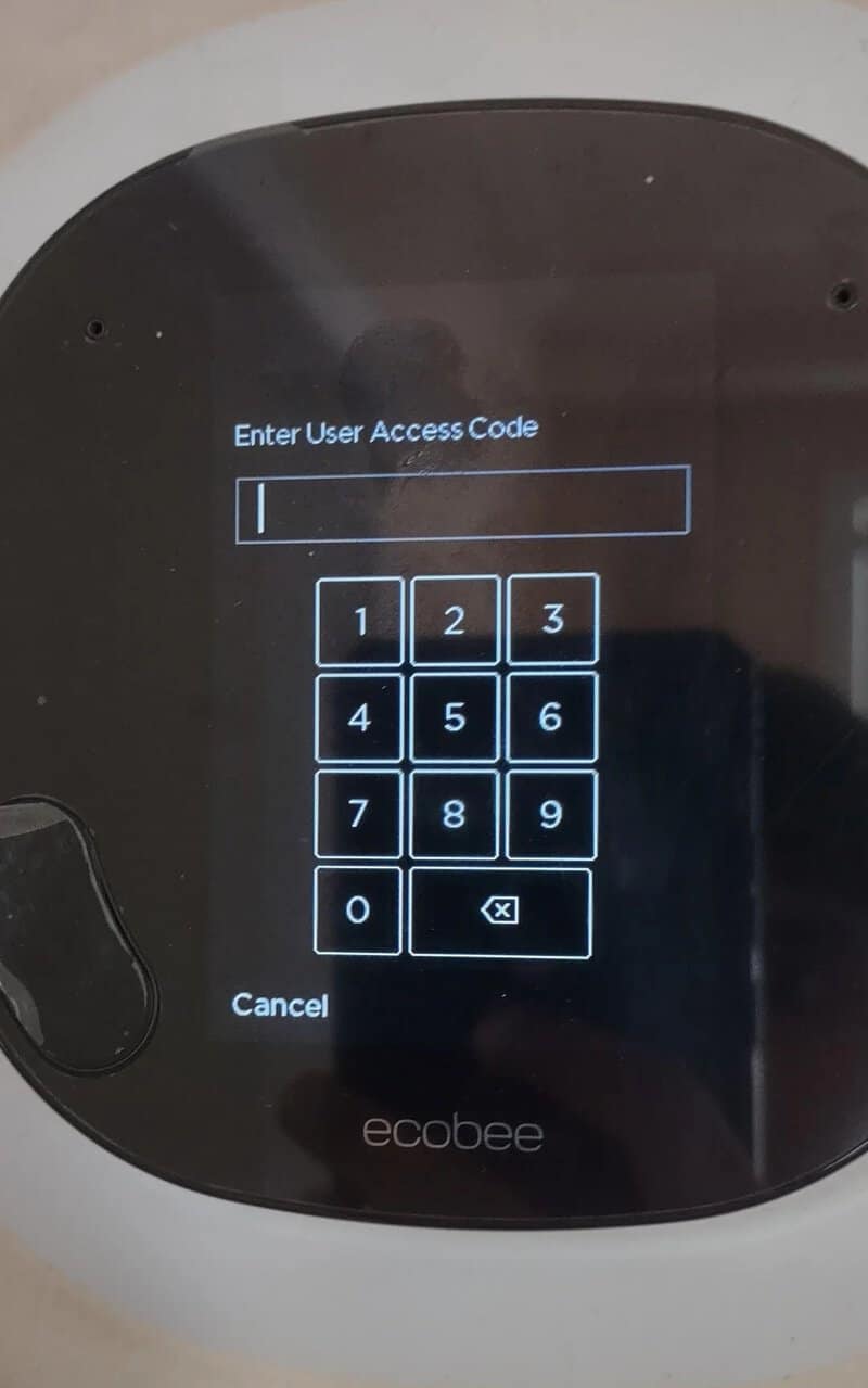 Touchscreen device with a user access code prompt and numeric keypad.