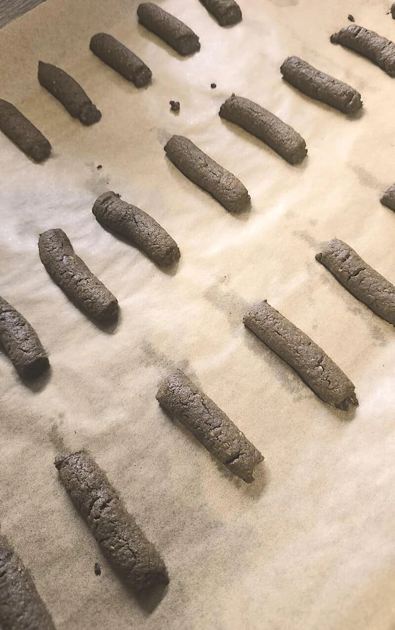 Charcoal sticks on parchment paper, some broken or uneven.