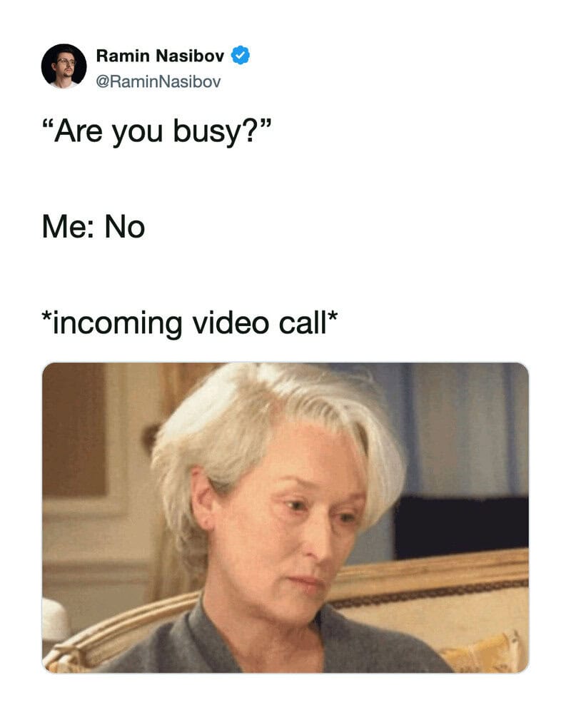 A woman with gray hair looks at her phone with a serious expression.