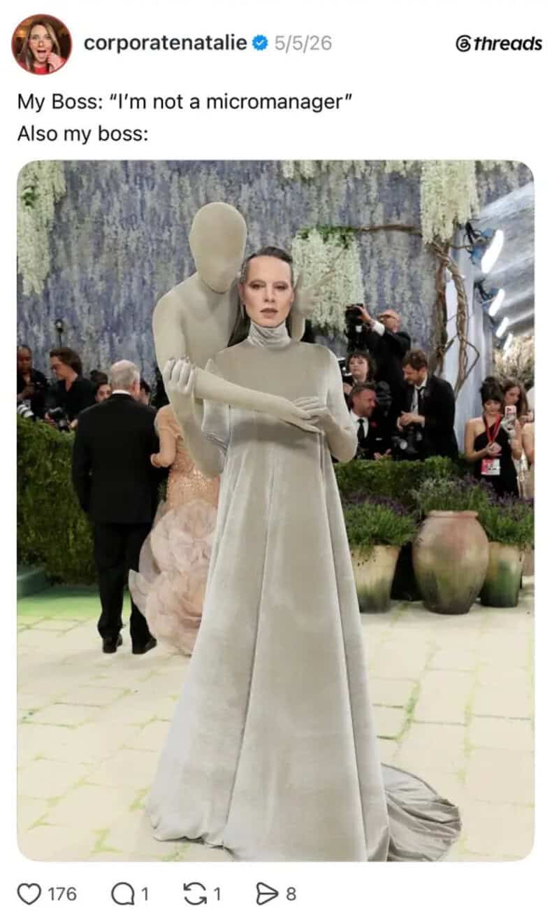 Woman in a long gray dress standing in front of a large sculpture at an event.
