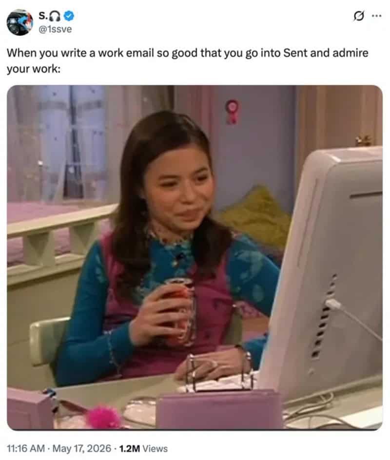 Young woman smiling at computer with a drink in hand, working from home.