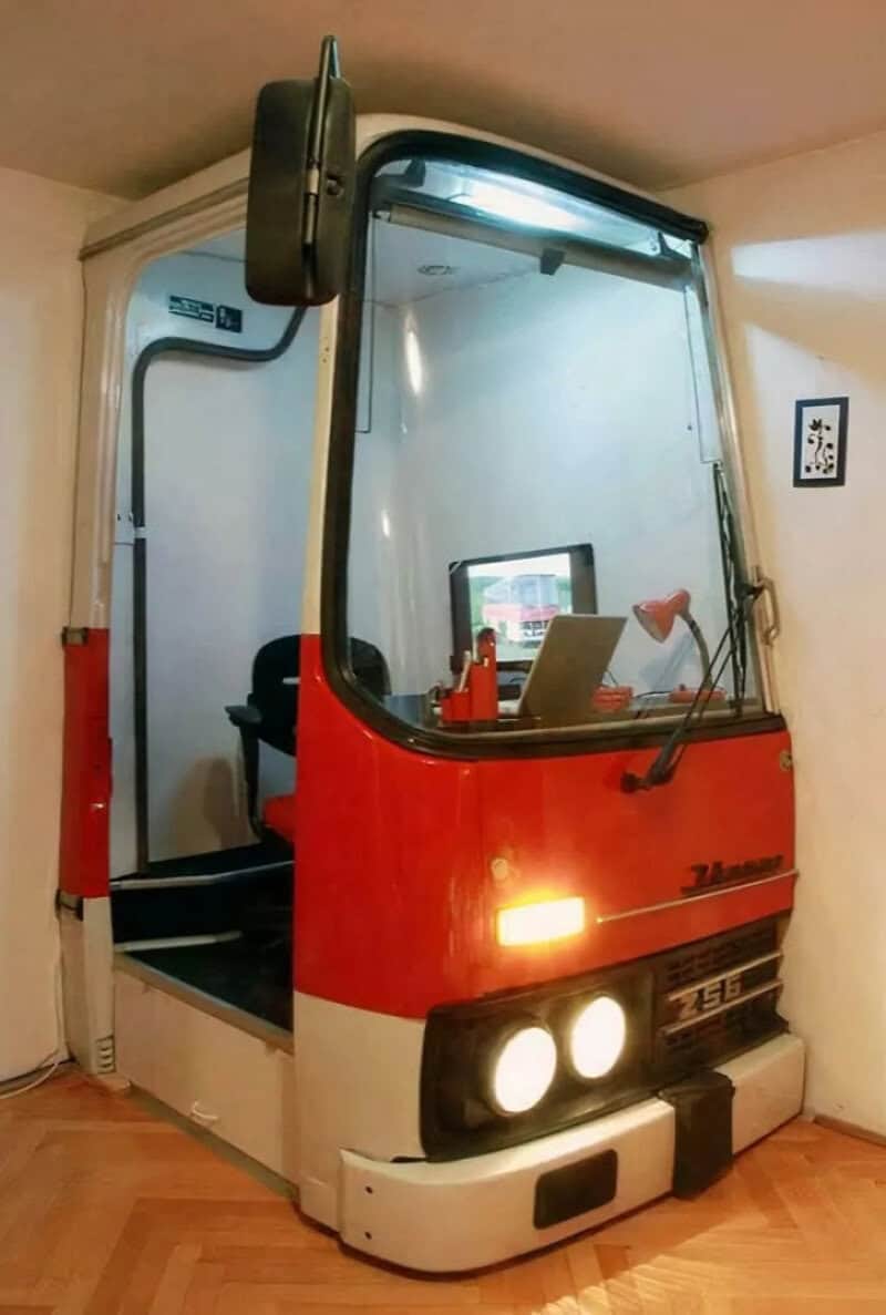 A small vehicle converted into a mobile workspace with a laptop and tools inside.