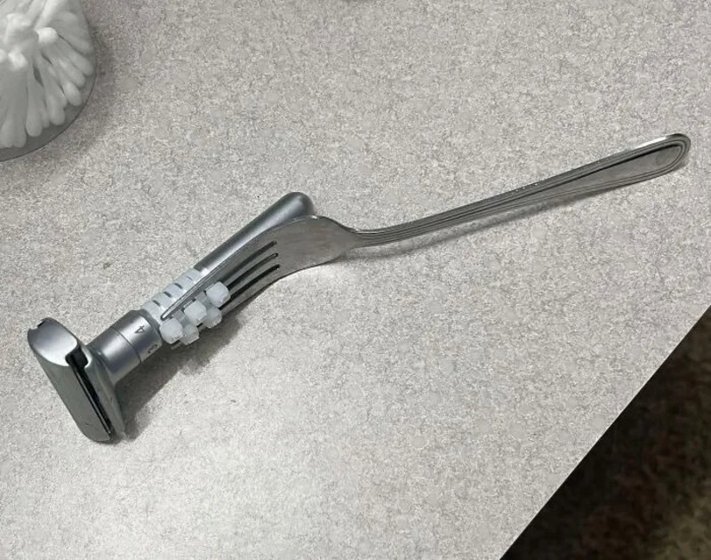 A razor blade attached to a fork, creating a makeshift shaver.