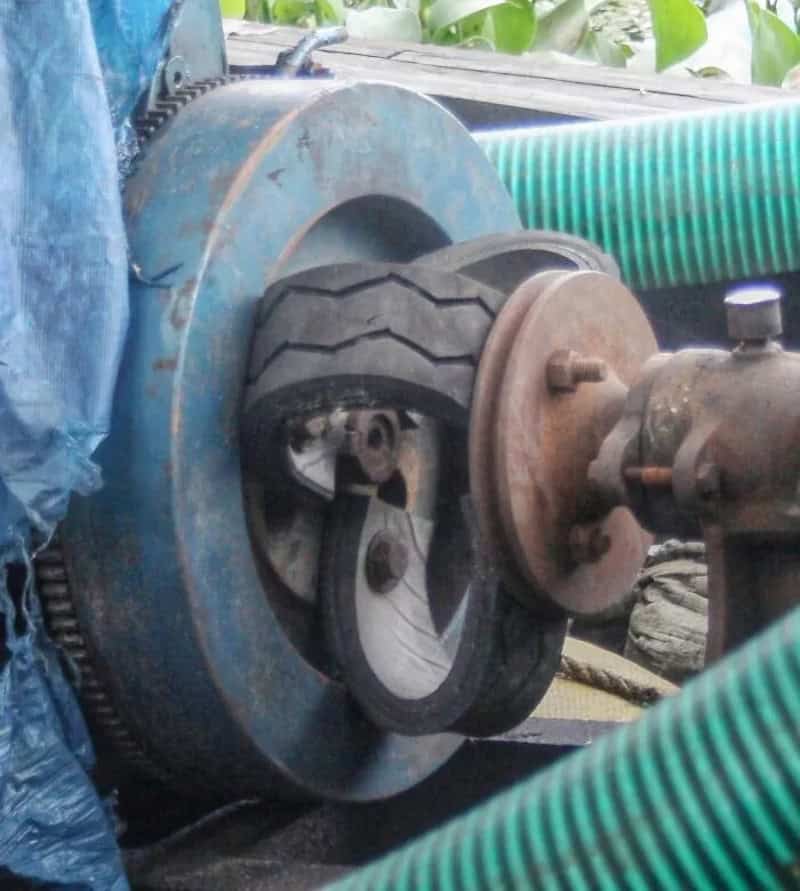 A makeshift wheel setup with a tire mounted on a metal disc, attached to a rusty axle.