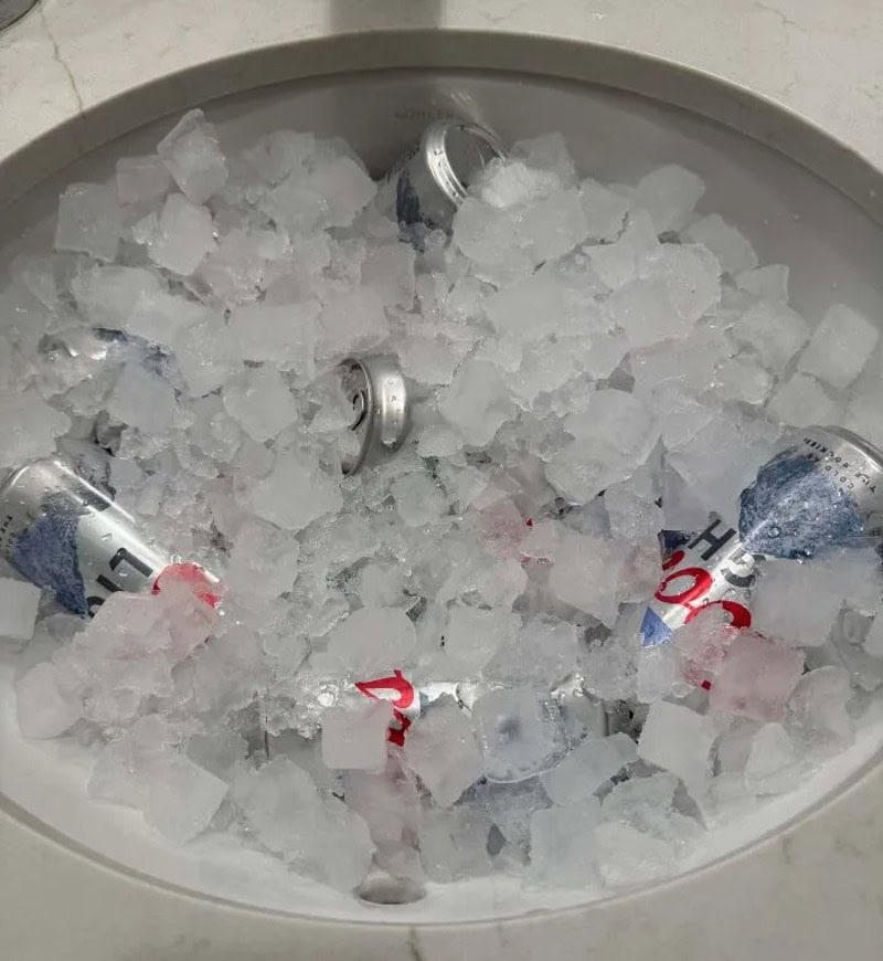 Cans of soda in ice, with some cans partially visible and crushed.