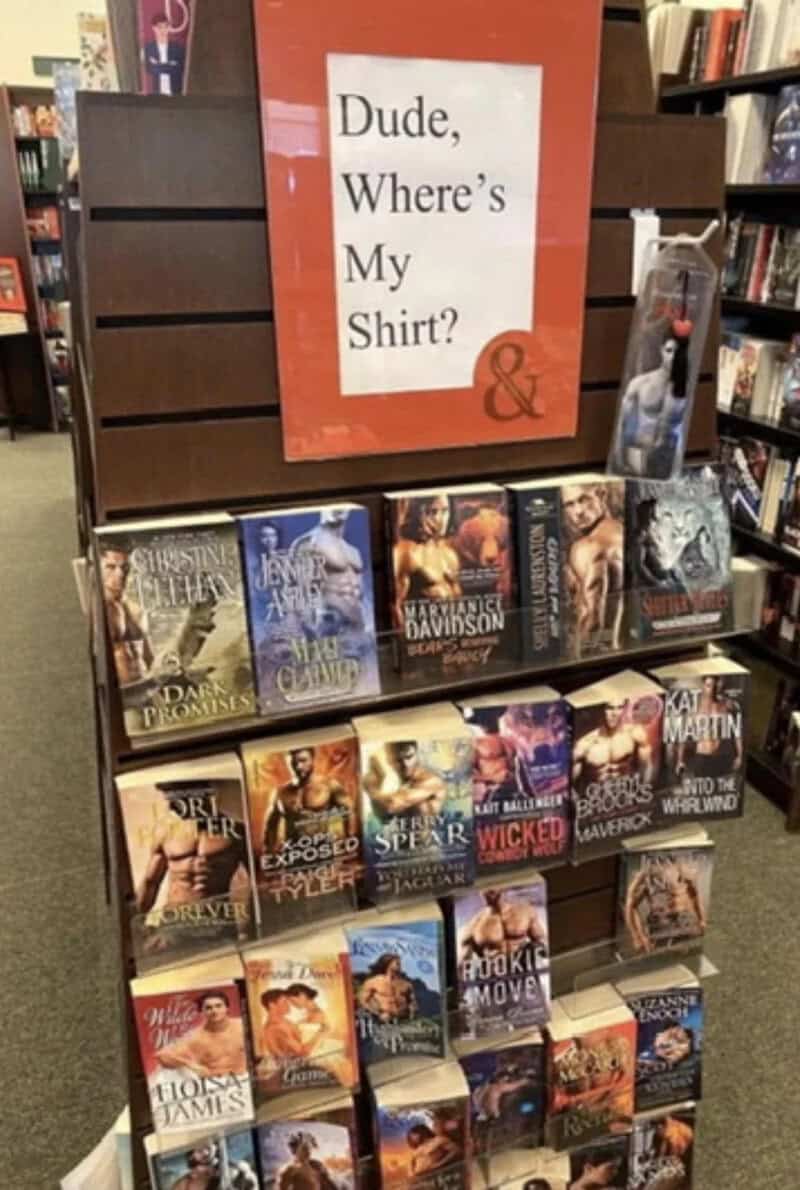 Sign reading "Dude, Where's My Shirt?" above a display of books.