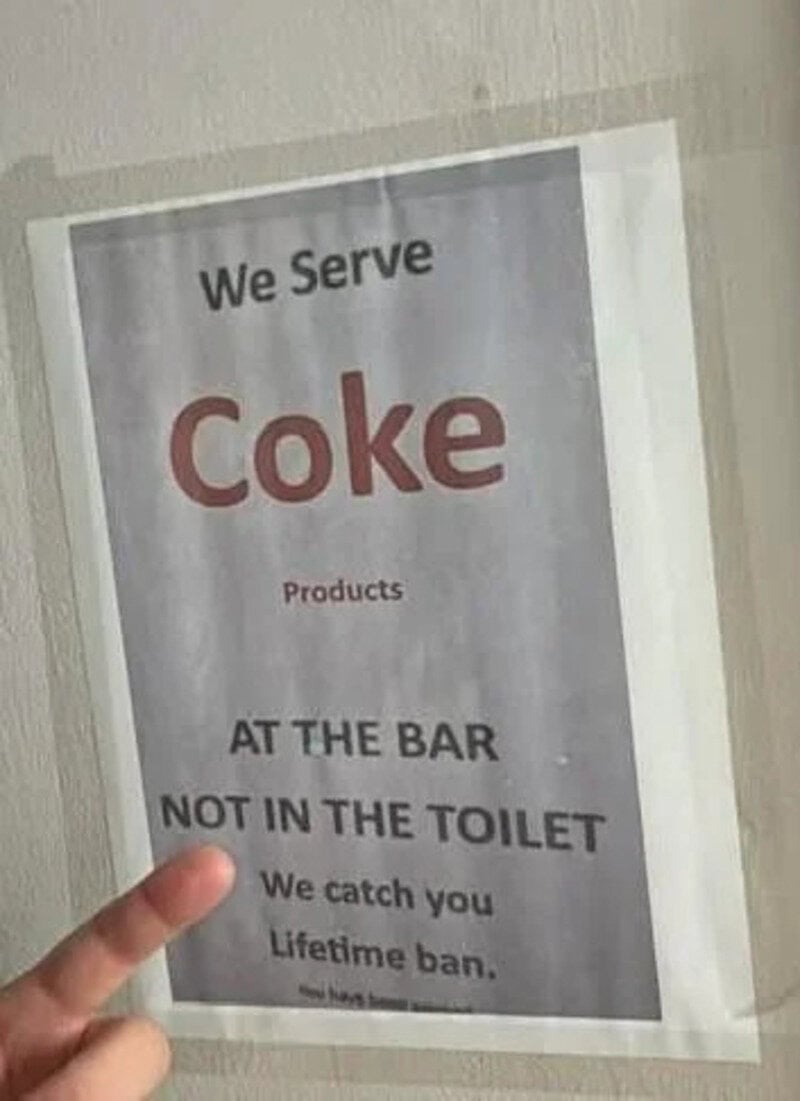 Sign says 'We Serve Coke Products at the bar, not in the toilet. We catch you, lifetime ban.'.