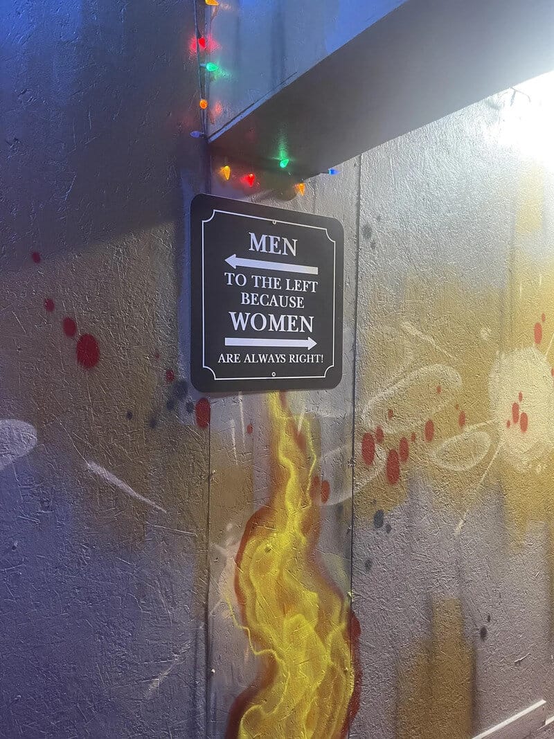 Humorous sign indicating men's and women's restrooms with a twist.