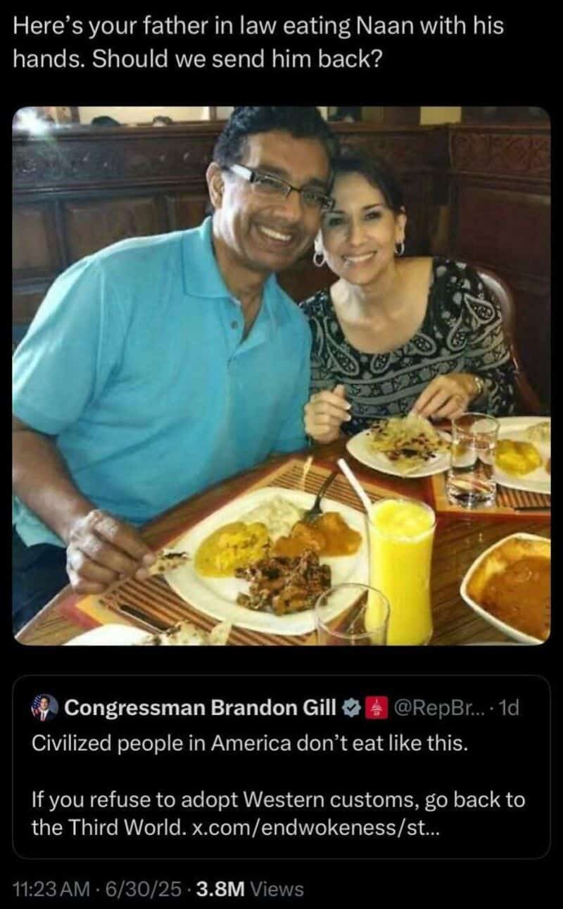 Father eating naan with his hands, smiling with daughter at a restaurant.
