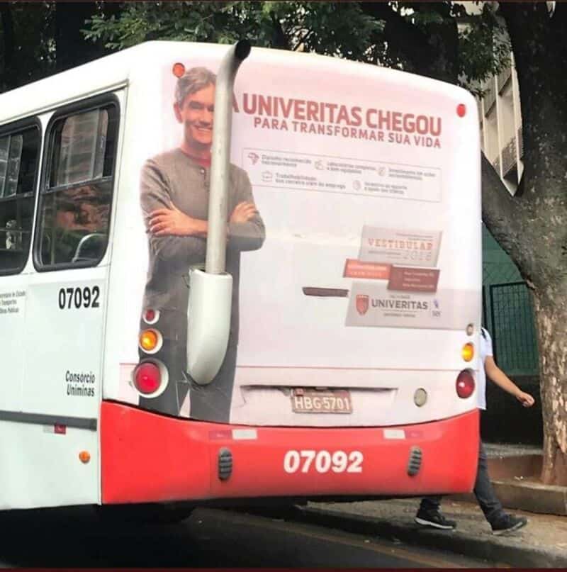Bus with an advertisement for UNIVERITAS and a person standing behind it.