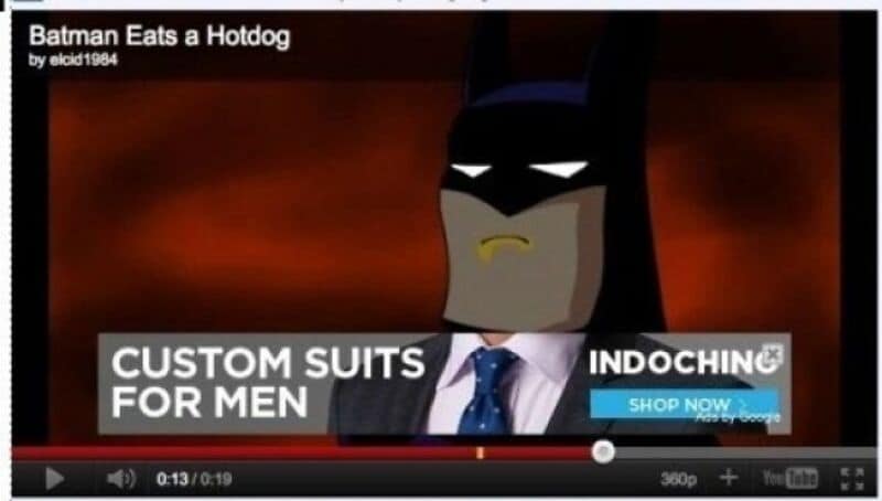 Batman eats a hotdog in a cartoon style, wearing a suit and tie.