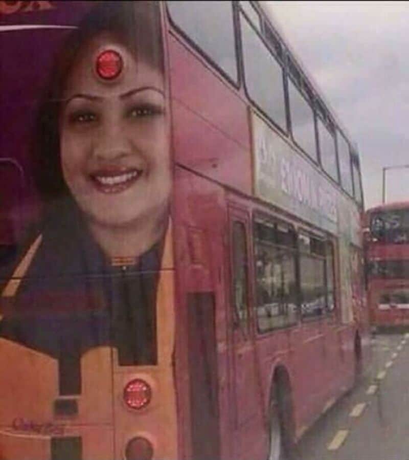 Bus with a woman's face on the side, smiling, with a red dot on her forehead.