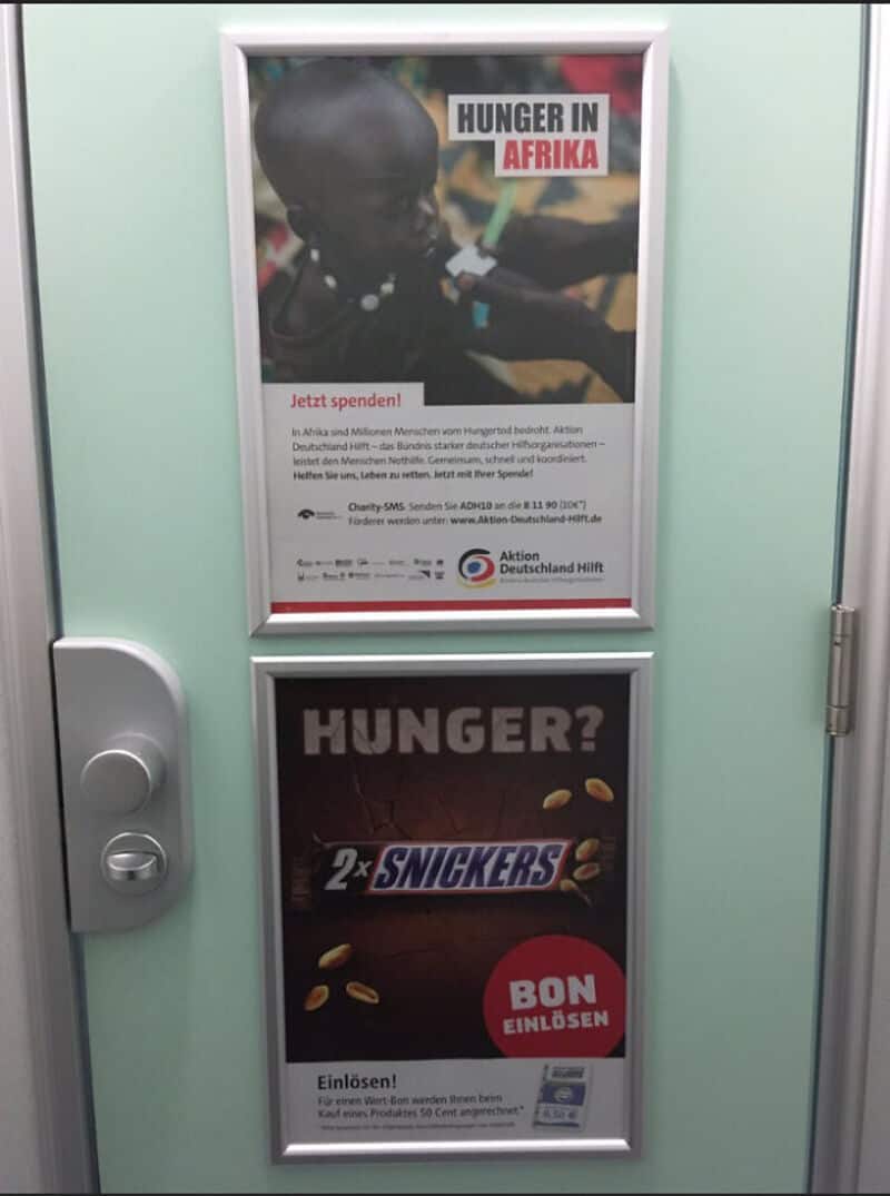Posters on a door about hunger in Africa and Snickers donation campaign.