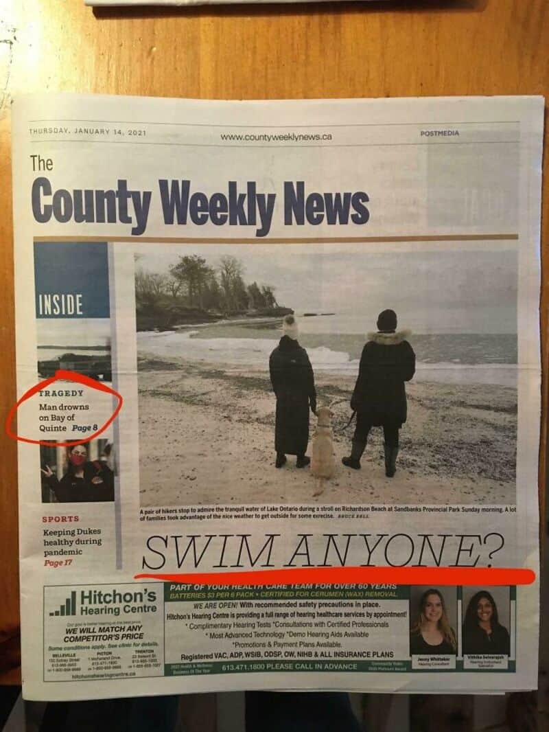Two people stand on a beach looking at the water, with a headline asking 'SWIM ANYONE?'.
