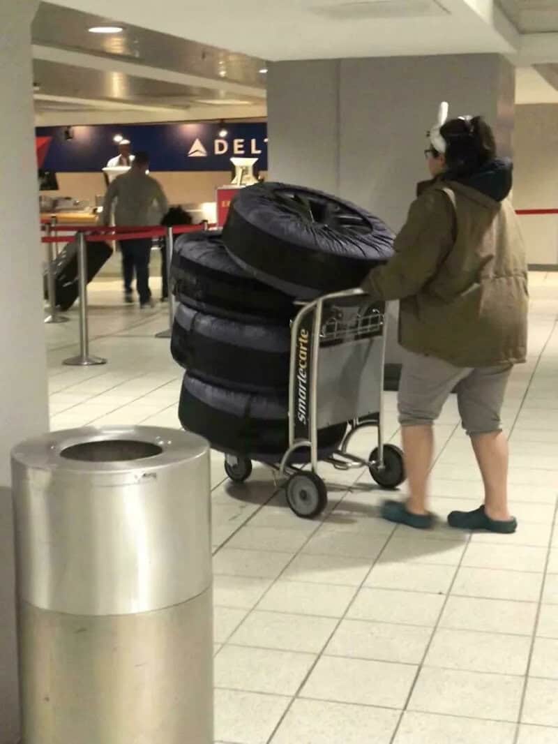 Person with a cart of tires at airport, funny airport photo.