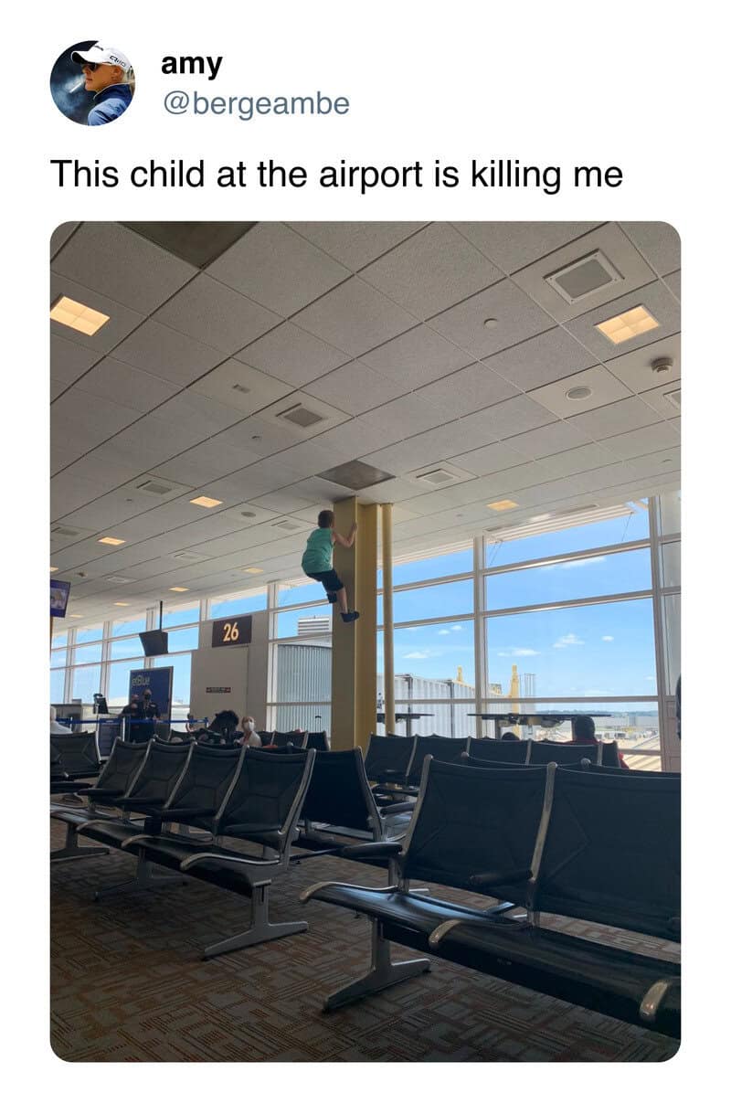 Child sitting on a pole at the airport, with empty seats and large windows in the background.