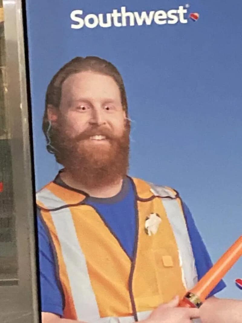 Man with a beard in a Southwest uniform holding a toy lightsaber.