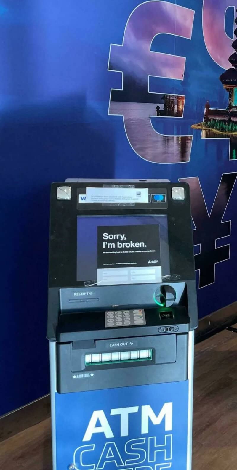 ATM machine with a broken screen displaying 'Sorry, I'm broken.'.
