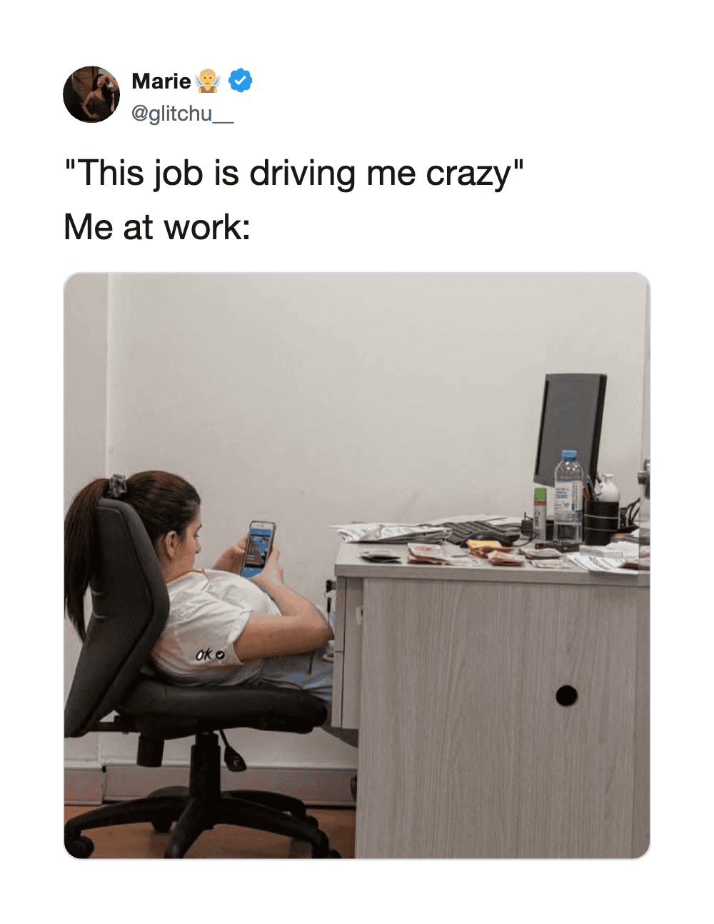 Woman sitting at desk looking at phone with caption about work stress.