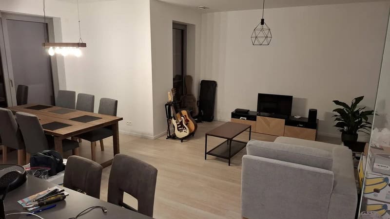 Living room with dining area, TV, guitar, and modern decor.