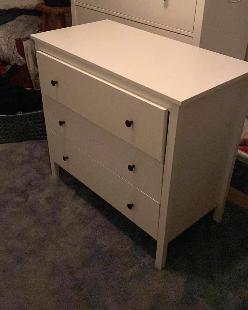 White dresser with three drawers, each with black heart-shaped handles.