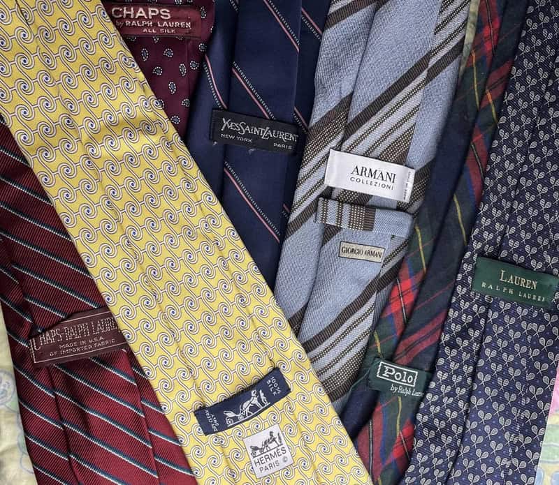 Collection of men's designer neckties with various patterns and labels.