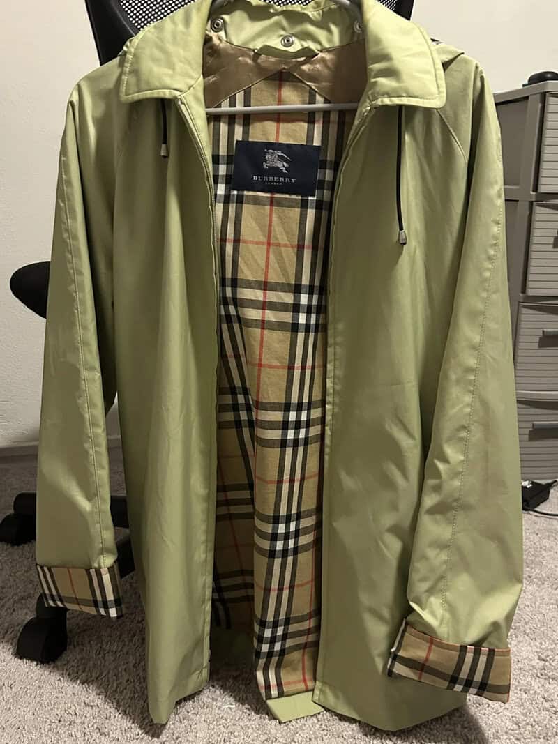 Light green Burberry raincoat with checkered lining and hood.