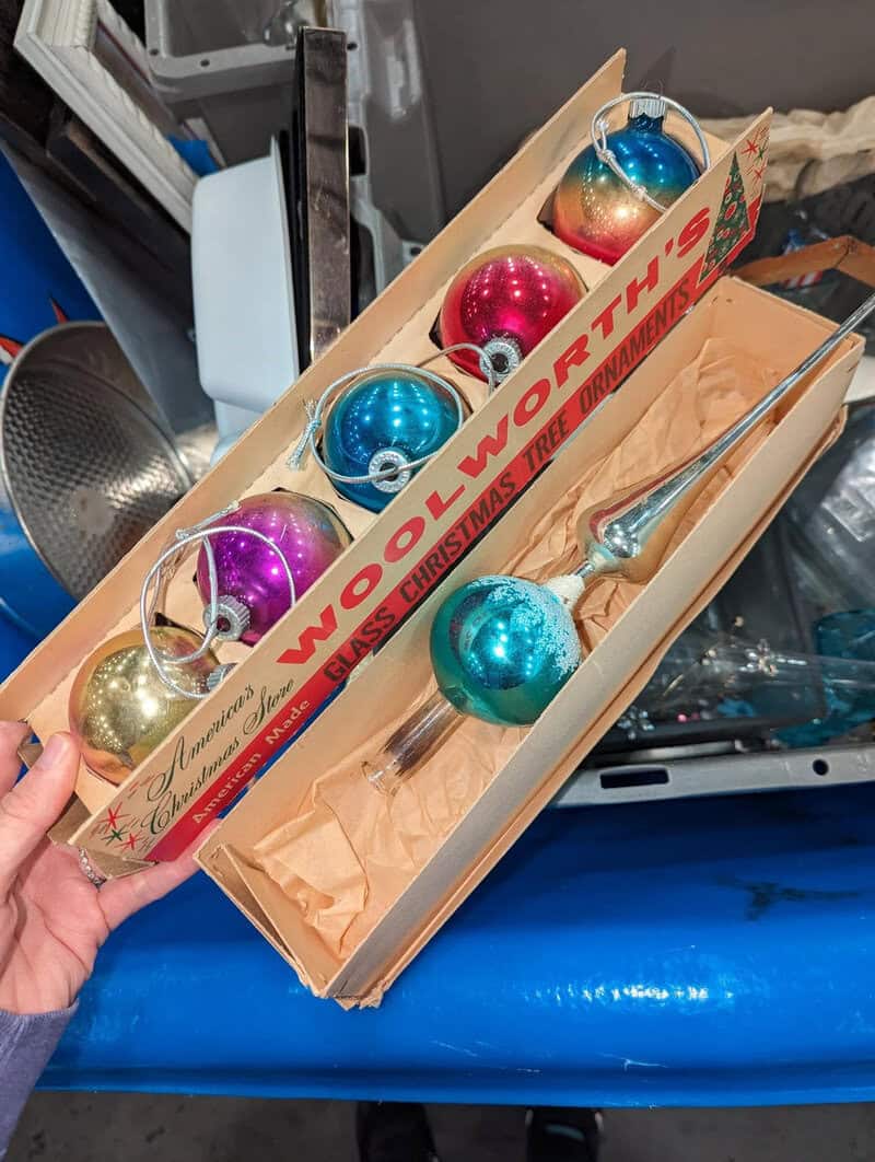 Colorful Christmas ornaments in a box with a Woodworth's label.