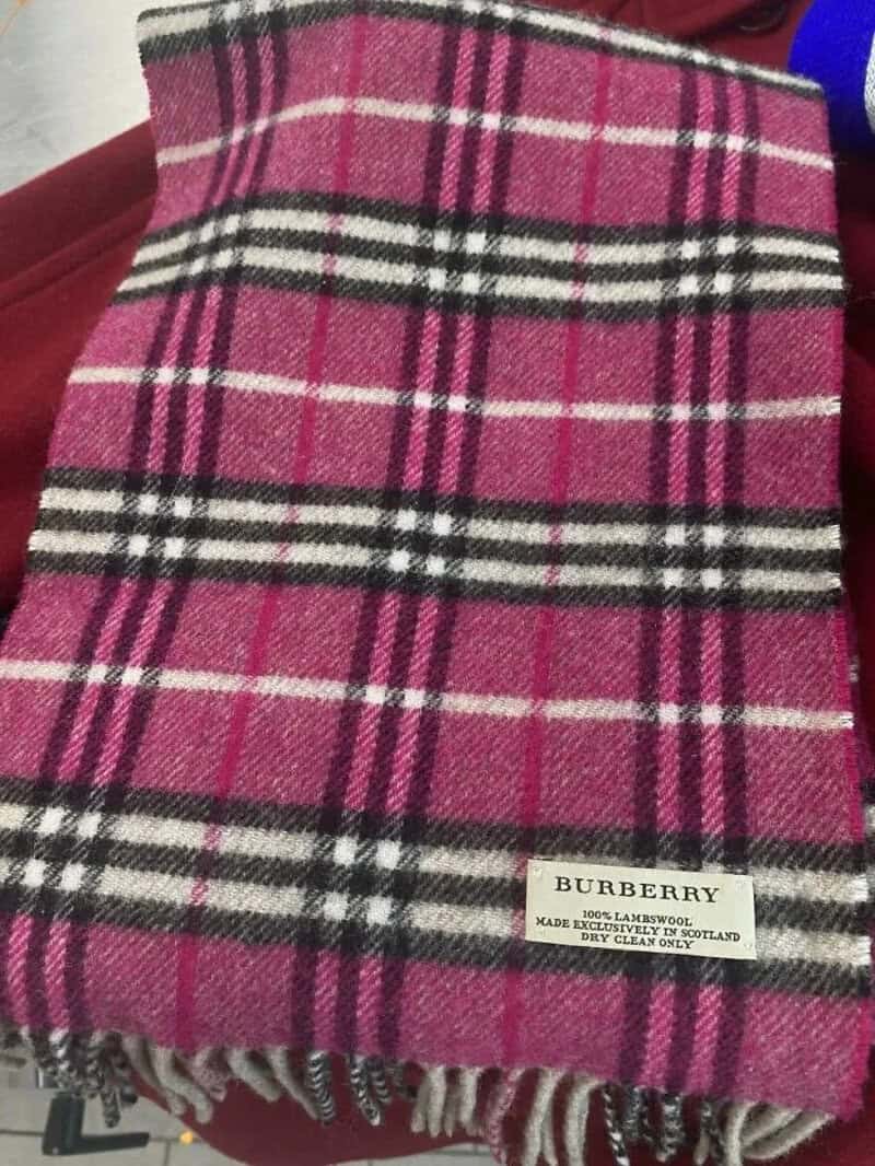Pink Burberry scarf with black, white, and pink plaid pattern.