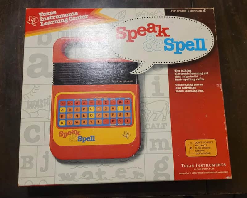 Speak & Spell electronic learning aid in red and yellow with keyboard, Texas Instruments logo.