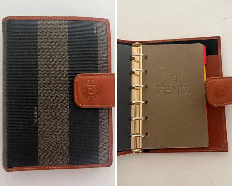 Fendi planner with striped cover and leather strap closure.