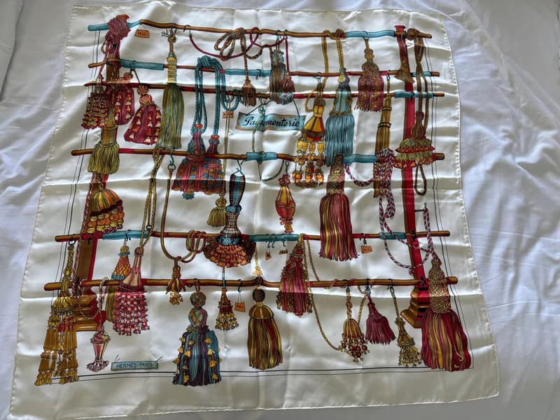 Colorful tassel jewelry on a grid display, with a 'Goodwill' tag in the center.