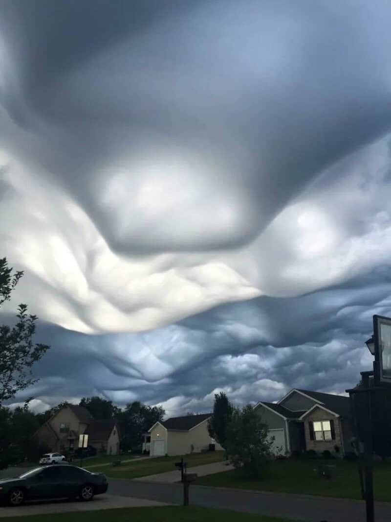 Dark, swirling storm clouds over a suburban neighborhood.